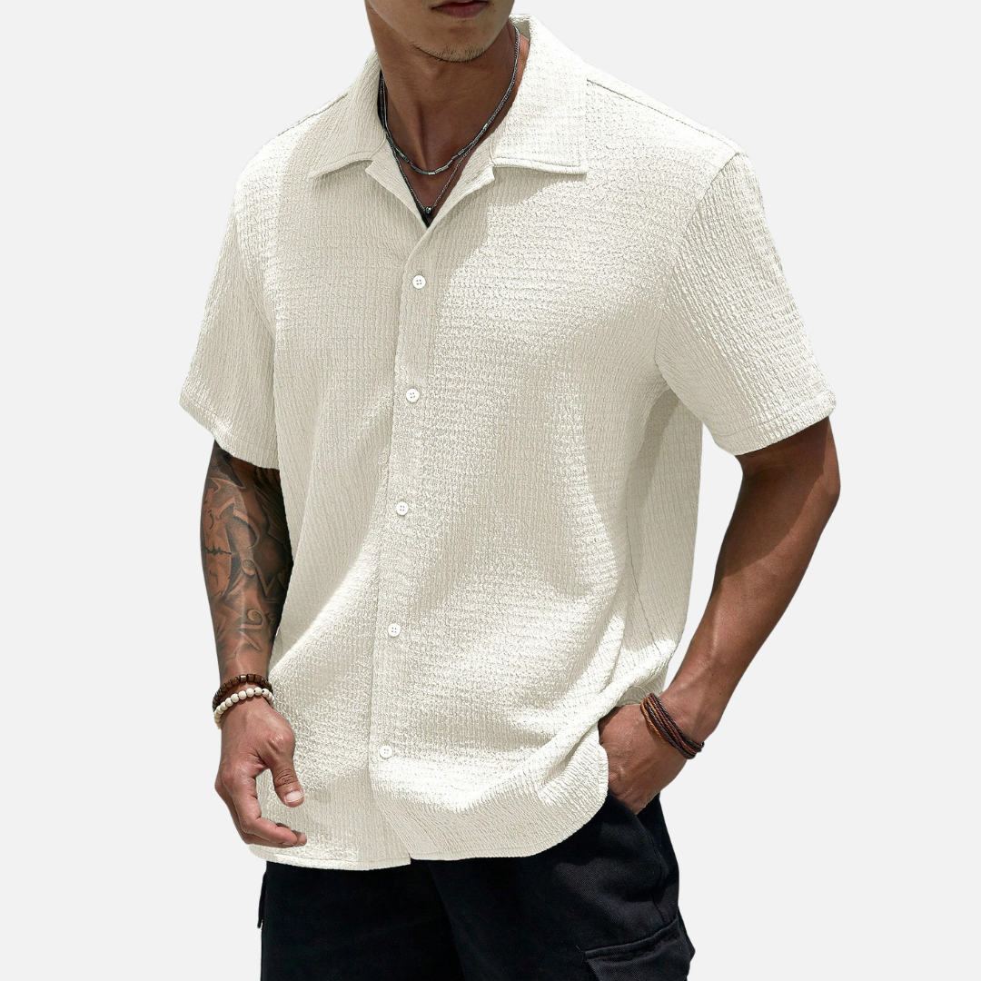 Camisa de meia abotoadura em cor sólida, com caimento solto e design versátil, ideal para ocasiões casuais e sociais.