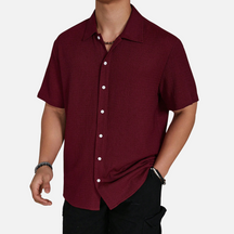 Camisa de meia abotoadura em cor sólida, com caimento solto e design versátil, ideal para ocasiões casuais e sociais.