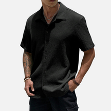 Camisa de meia abotoadura em cor sólida, com caimento solto e design versátil, ideal para ocasiões casuais e sociais.