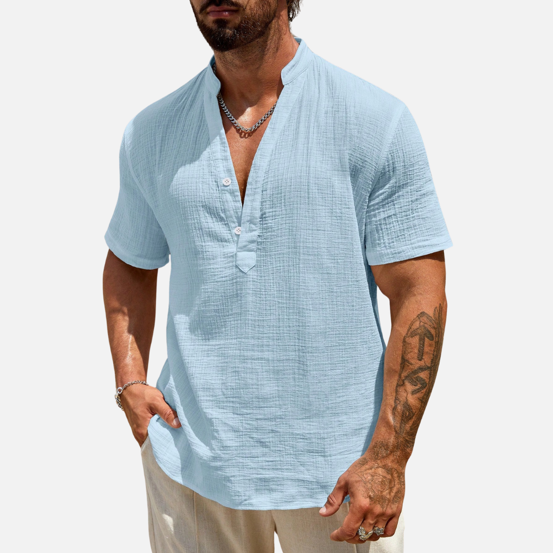 Camisa de meia abotoadura em cor sólida, com caimento solto e design moderno, ideal para conforto e estilo em ocasiões casuais.