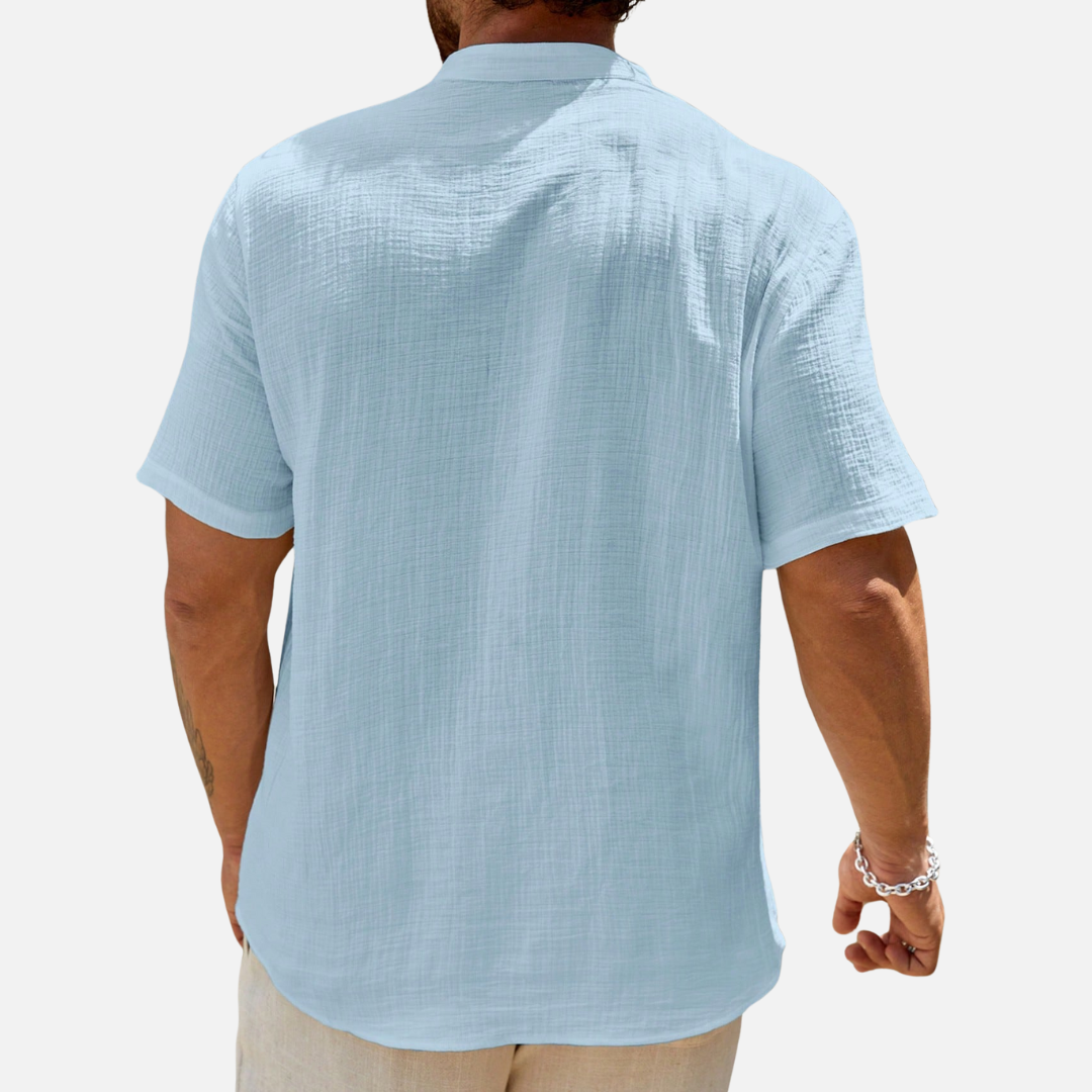 Camisa de meia abotoadura em cor sólida, com caimento solto e design moderno, ideal para conforto e estilo em ocasiões casuais.